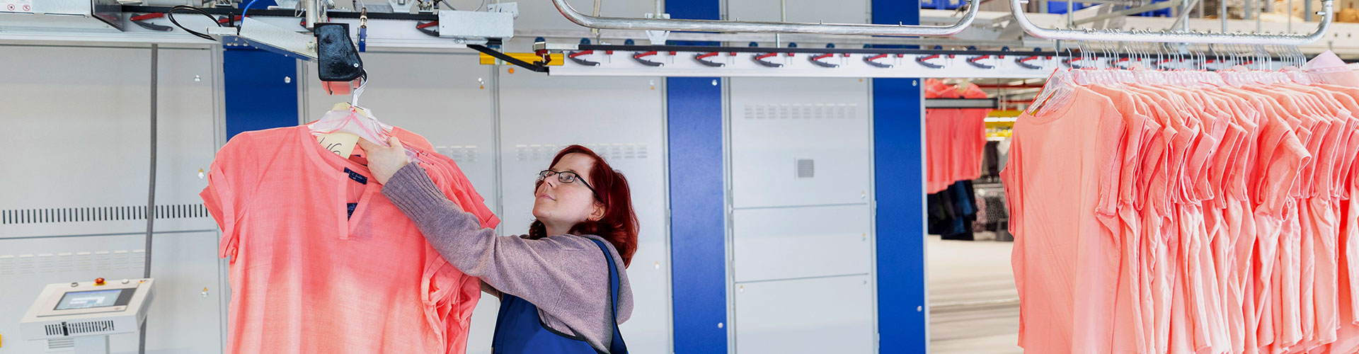 Person hangs clothes on assembly line | LGI